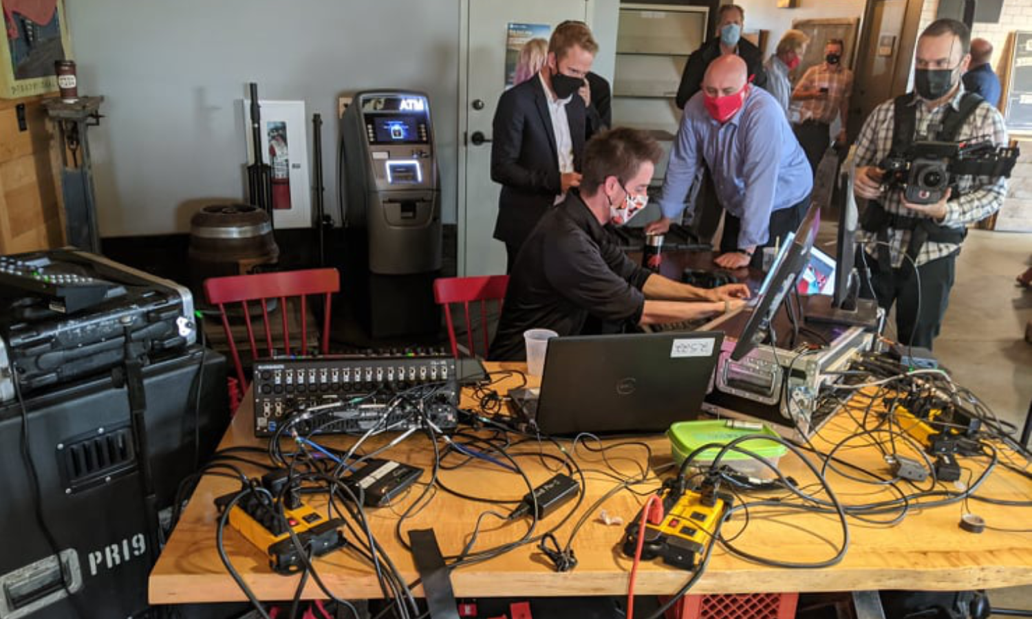 Michael and a client working at FOH for a political event in Fredericton NB. They are surrounded by livestream and audio equipment.