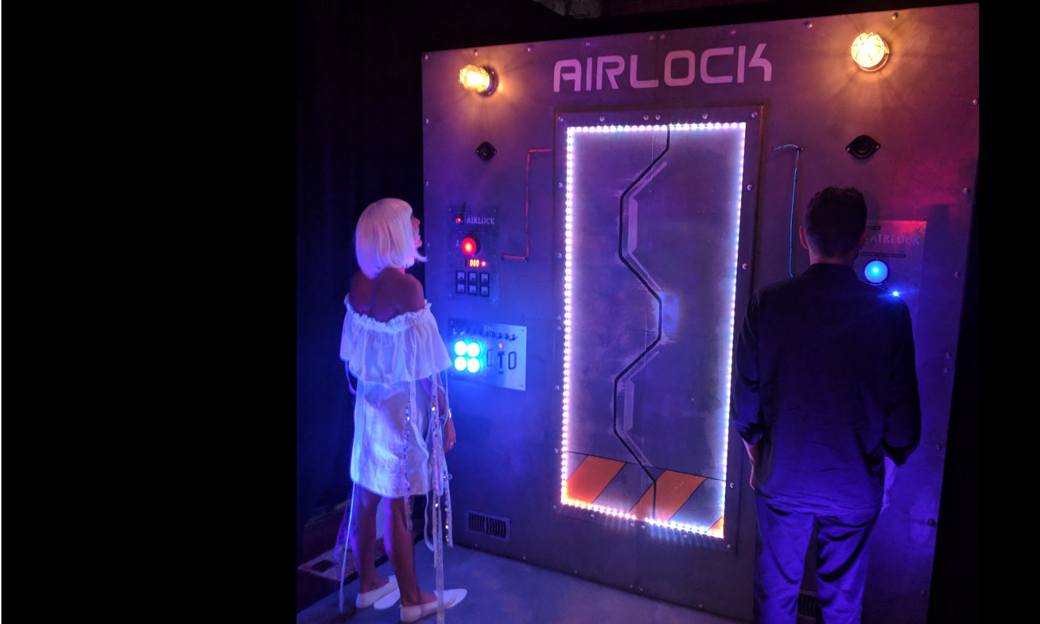 A costumed man and woman are interacting with our custom built Space Wall at a company retreat.